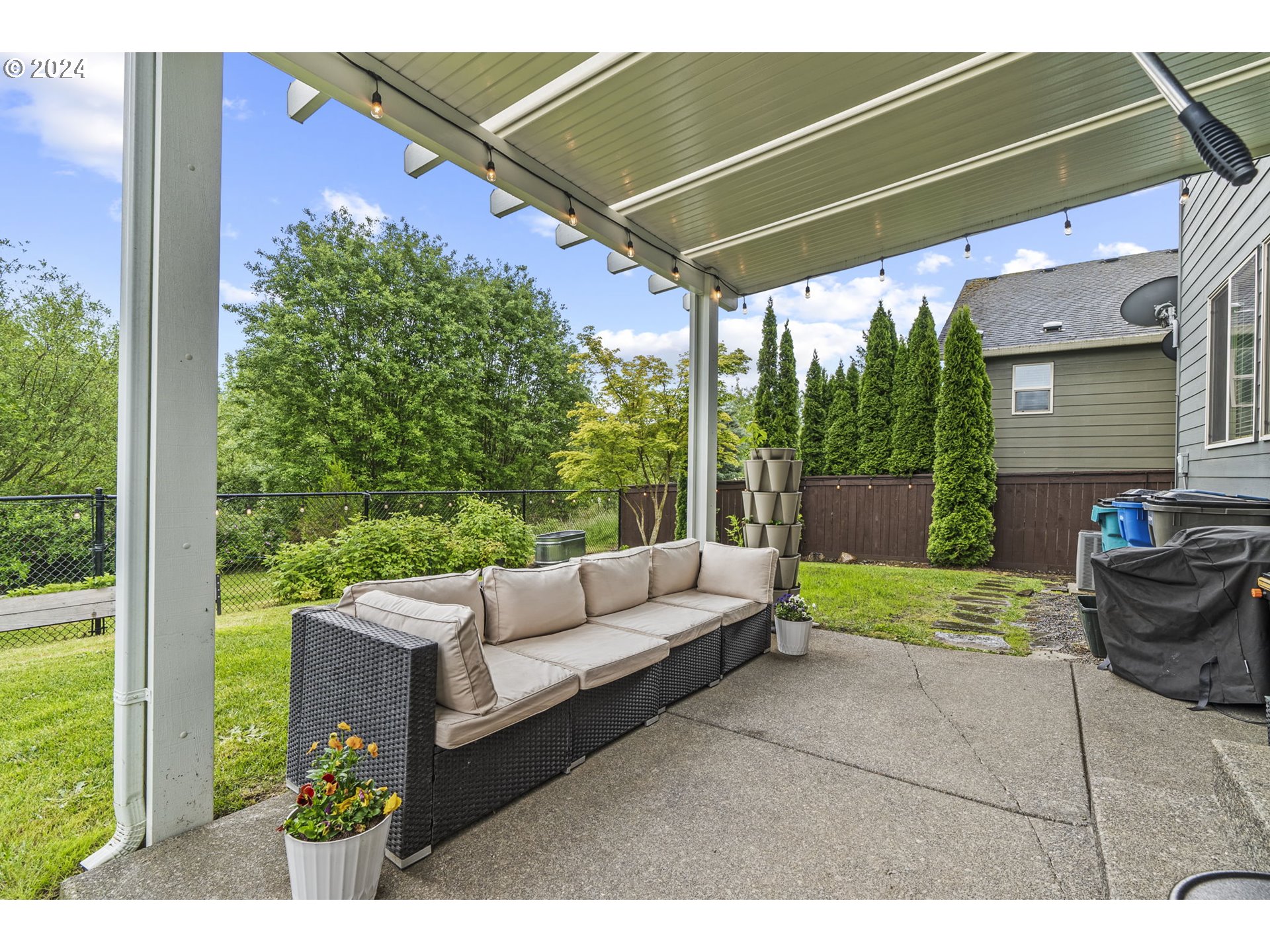 266 North Green Gables Loop Ridgefield, WA 98642 - Photo 33 of 37 a view of a patio with couches chairs potted plants and a palm tree