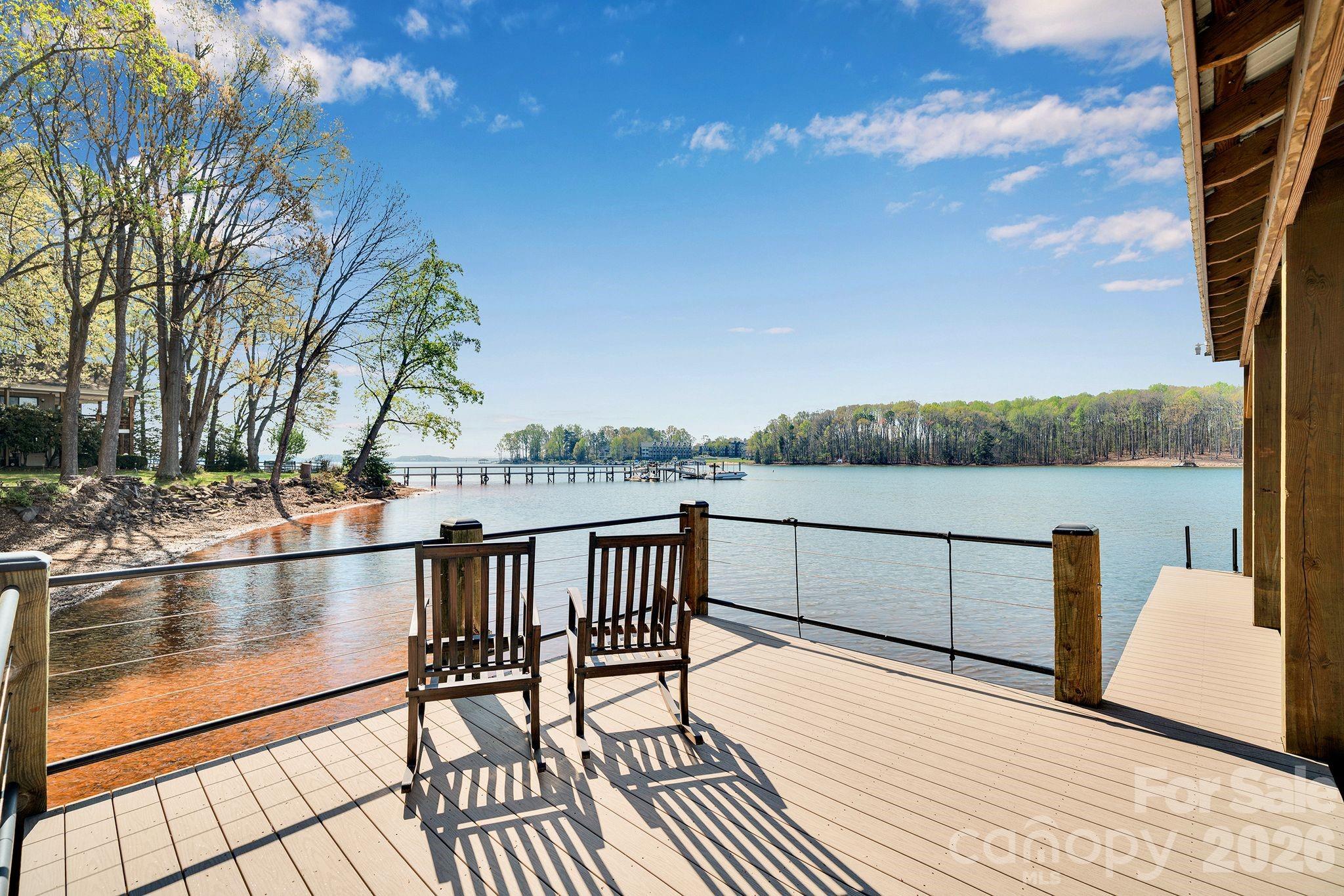 a view of a balcony with wooden floor and lake view