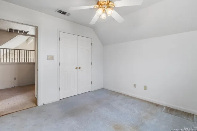 an empty room with a ceiling fan and a window