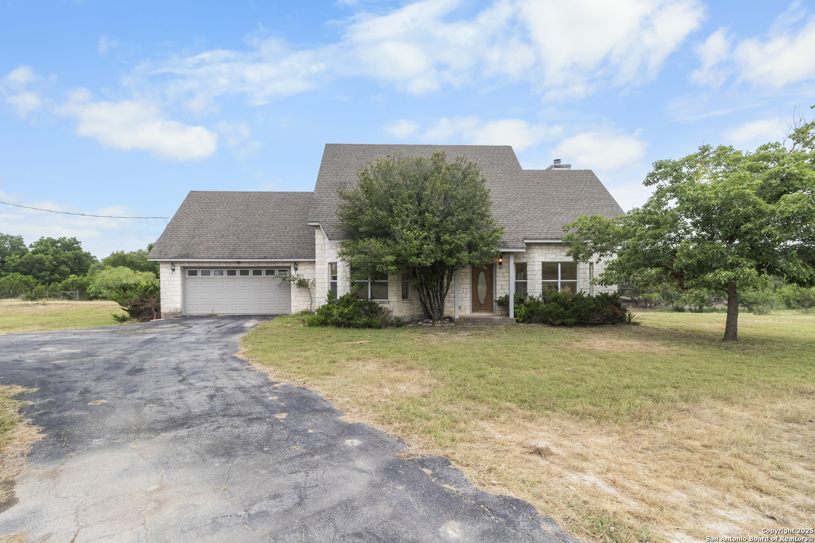 369 Deer Valley Bandera, TX 78003 - Photo 3 of 34 a front view of a house with a yard and garage