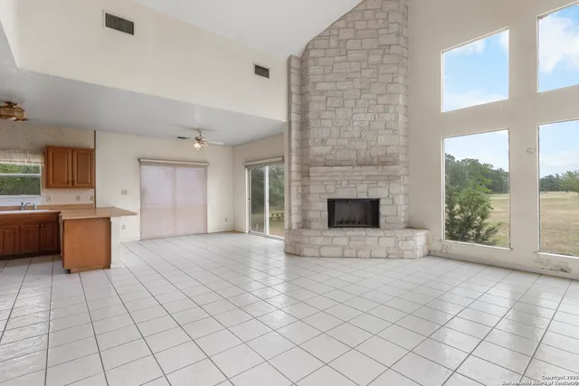 a view of an empty room with a fireplace and a window