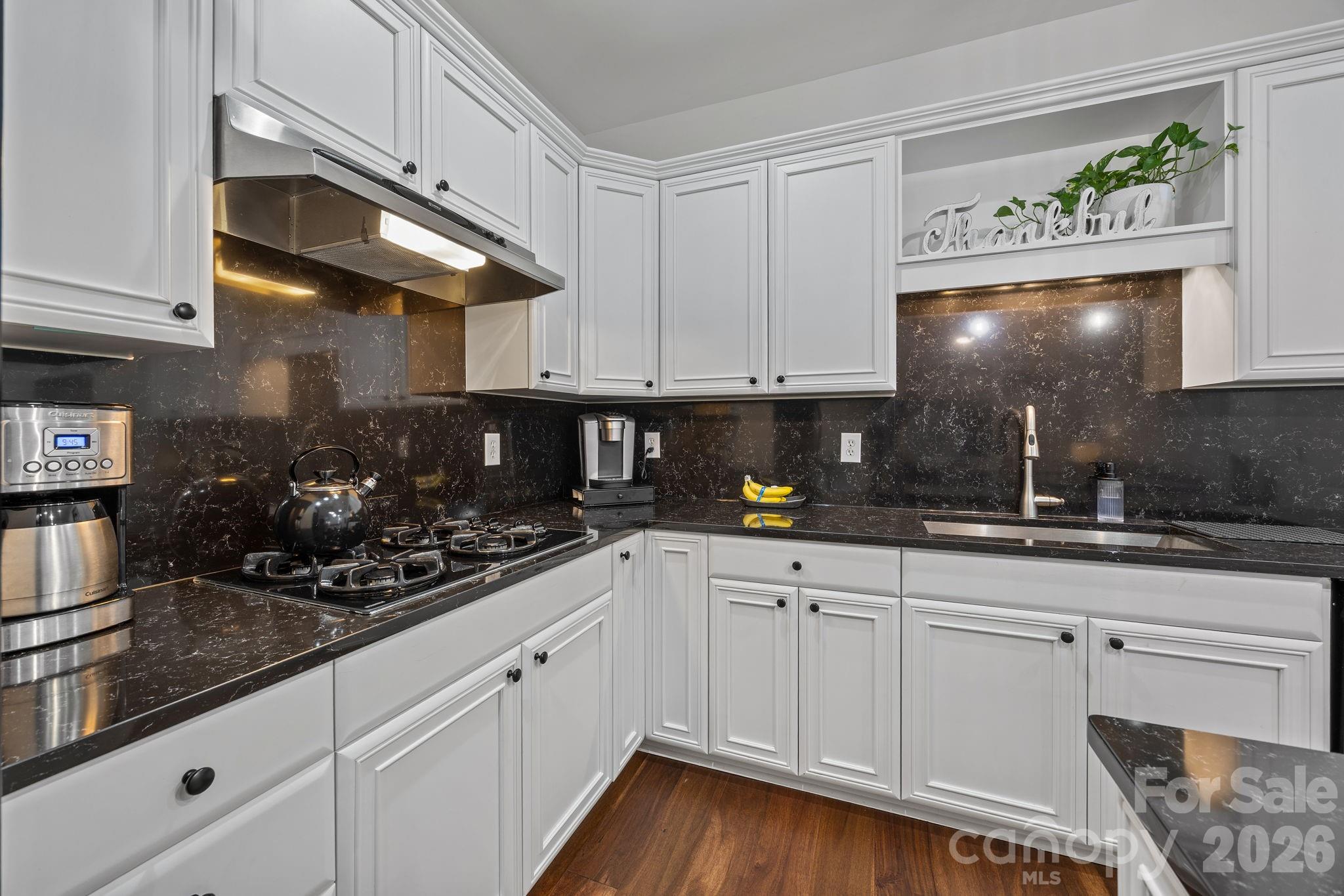 233 Twain Avenue Davidson, NC 28036 - Photo 12 of 35 a kitchen with white cabinets and chandelier