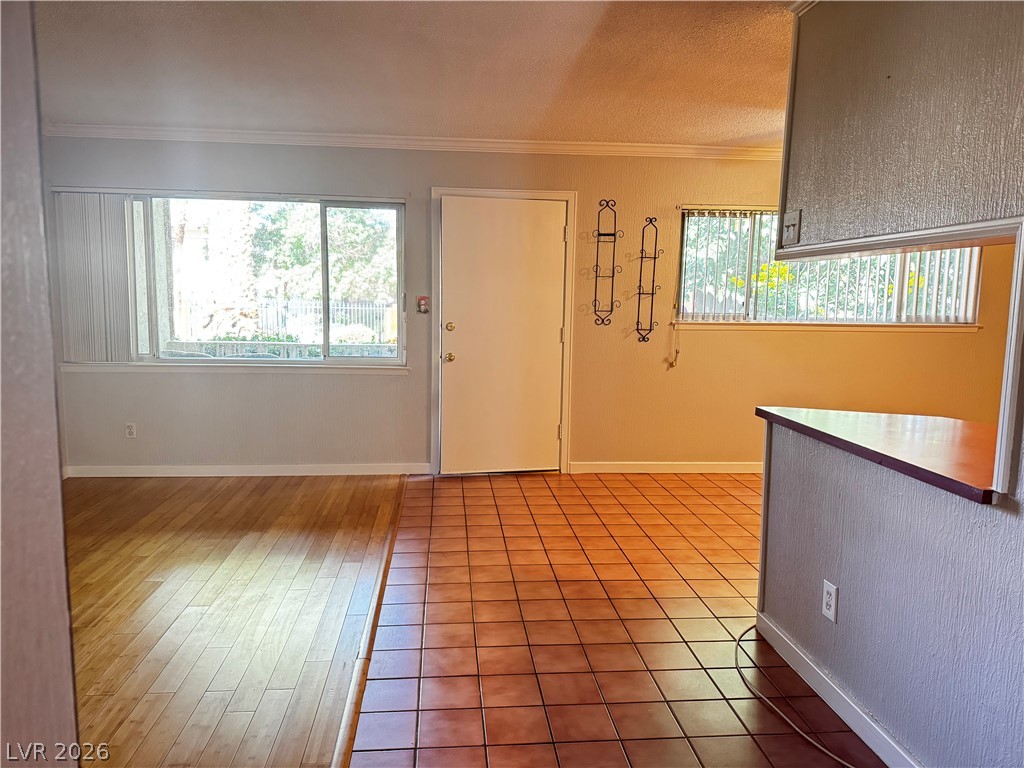 350 East Desert Inn Road, Unit C103 Las Vegas, NV 89109 - Photo 14 of 23 Hardwood and tile flooring combine for a clean, flowing living area with bright window views.