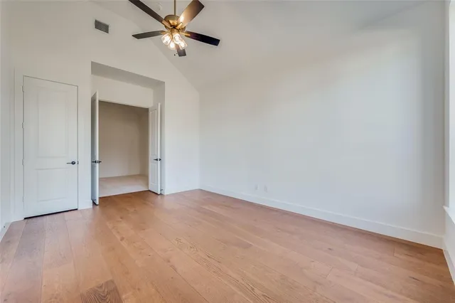 a view of an empty room and chandelier fan
