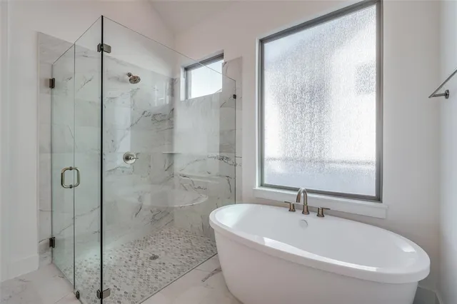 a white bath tub sitting next to a shower