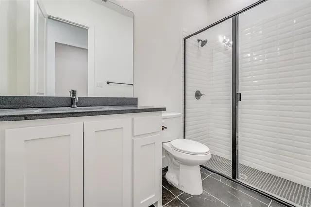 a bathroom with a granite countertop sink toilet and a mirror