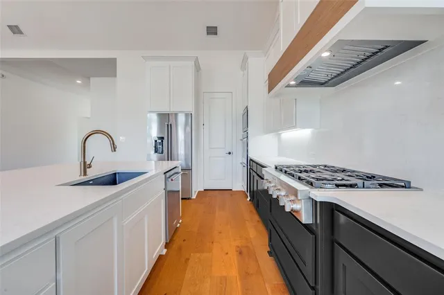 a kitchen with stainless steel appliances granite countertop a stove and a sink