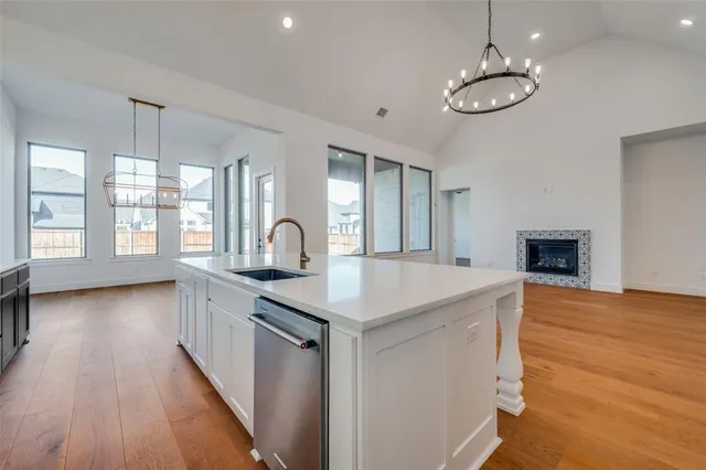 a kitchen with stainless steel appliances granite countertop a sink cabinets a dining table and chairs