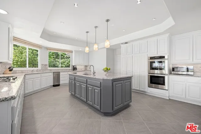 a large kitchen with kitchen island a large counter space appliances and a window