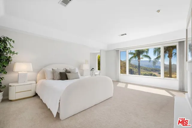 a bedroom with a bed and a potted plant