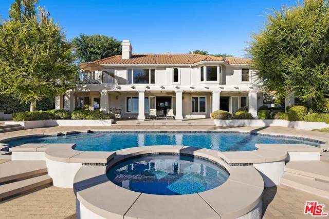 a view of a house with swimming pool and sitting area