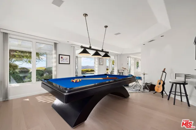 a spacious en suite bathroom with a double vanity sink a mirror and a bathtub