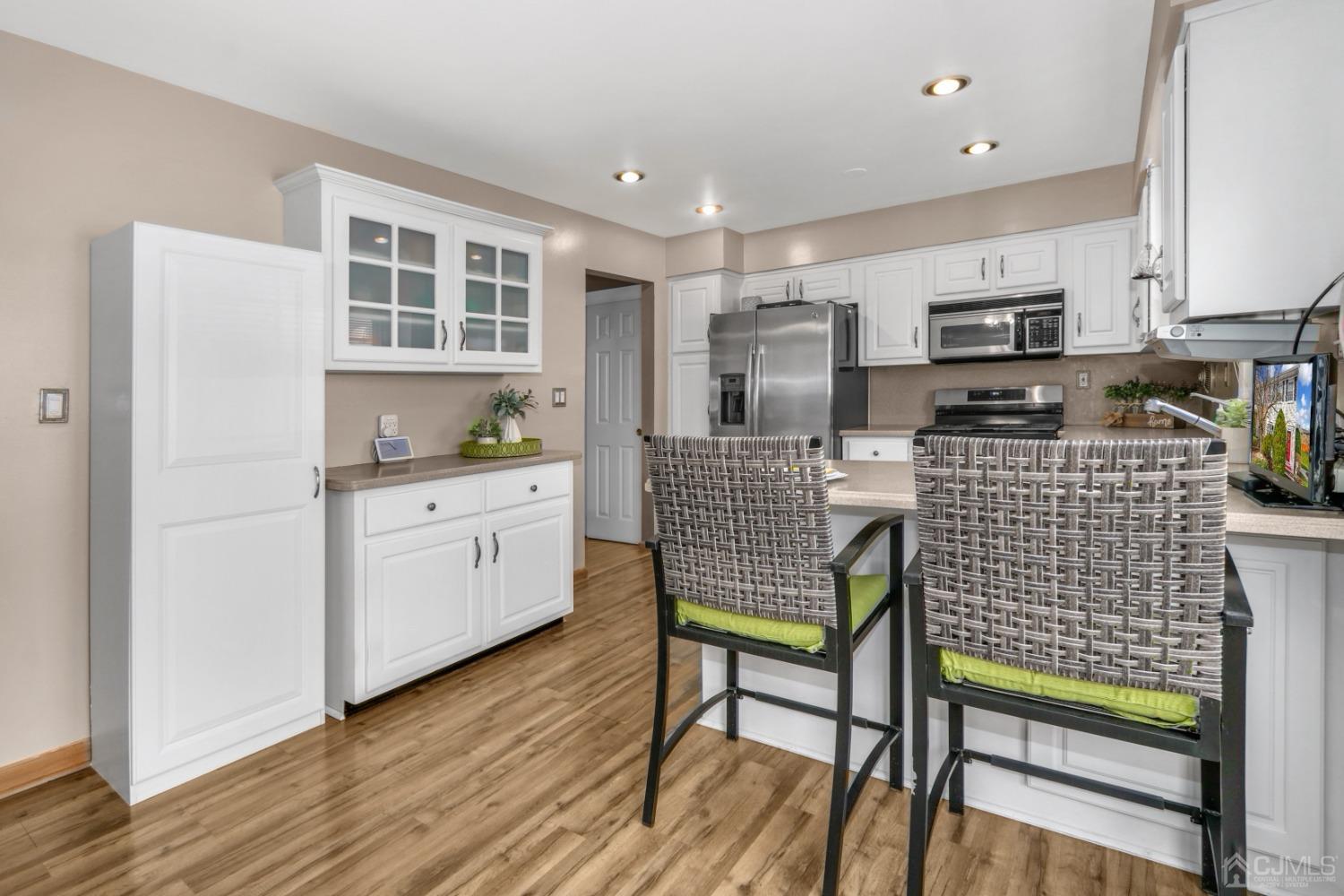 165 Howell Avenue Fords, NJ 08863 - Photo 12 of 31 a kitchen with stainless steel appliances kitchen island granite countertop a stove top oven a sink a dining table and chairs