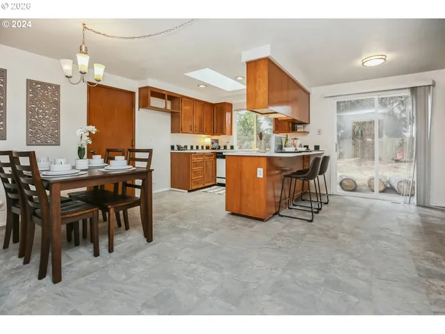 a open kitchen with stainless steel appliances kitchen island granite countertop a table and chairs in it