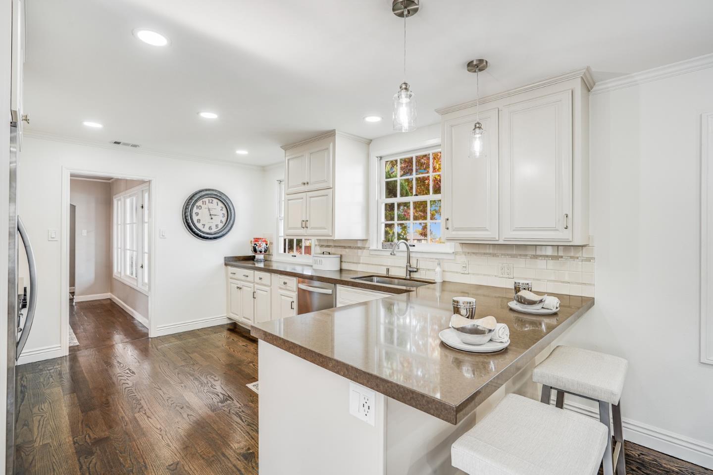 100 Chestnut Street San Carlos, CA 94070 - Photo 14 of 45 a kitchen with a sink dishwasher a stove a dining table and chairs with wooden floor