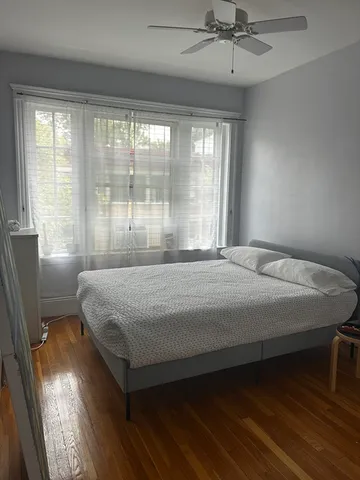 a bedroom with a large bed and two windows