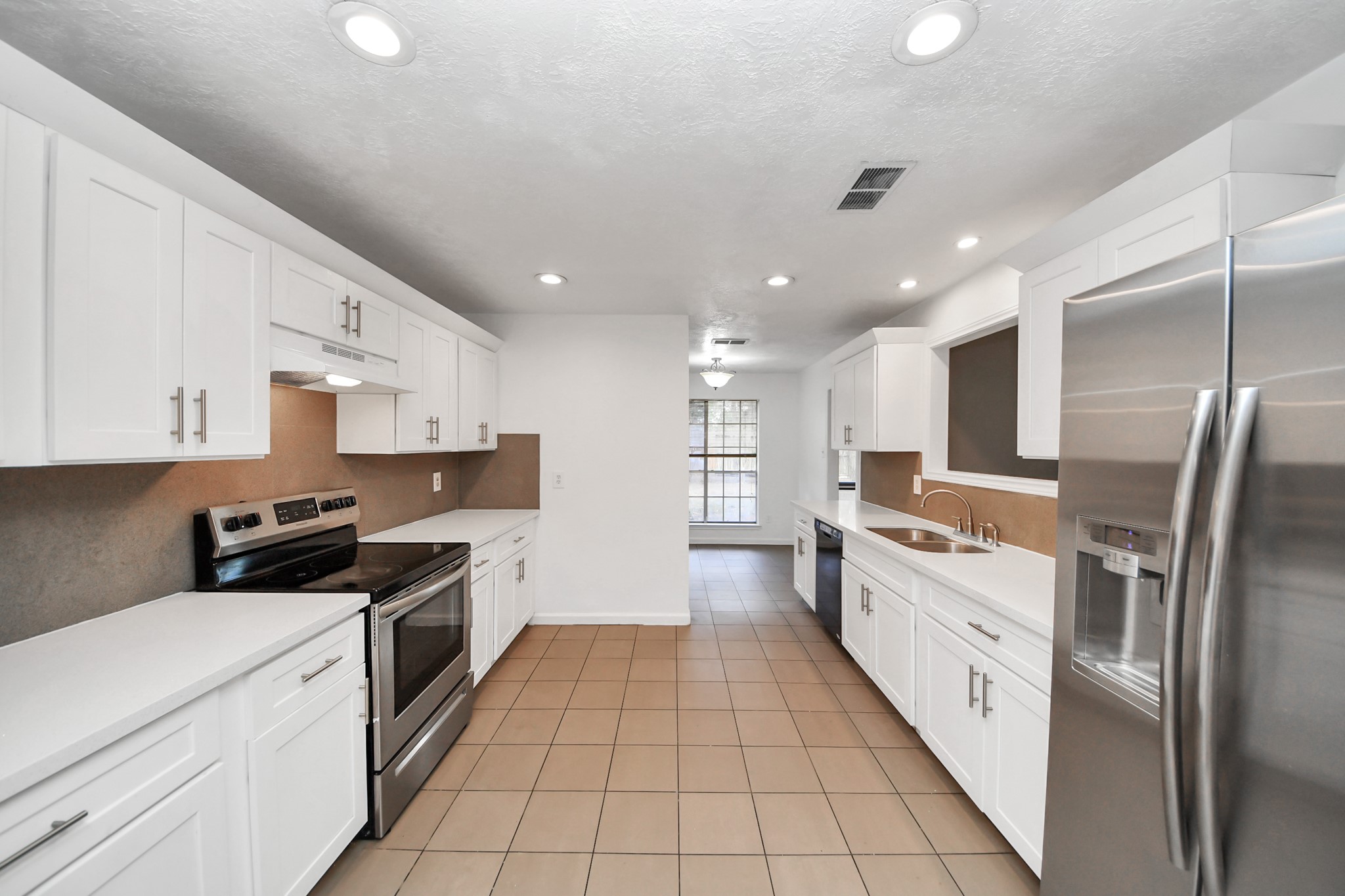 411 Dover Lane Spring, TX 77373 - Photo 15 of 40 a large kitchen with stainless steel appliances granite countertop a stove a sink and a refrigerator