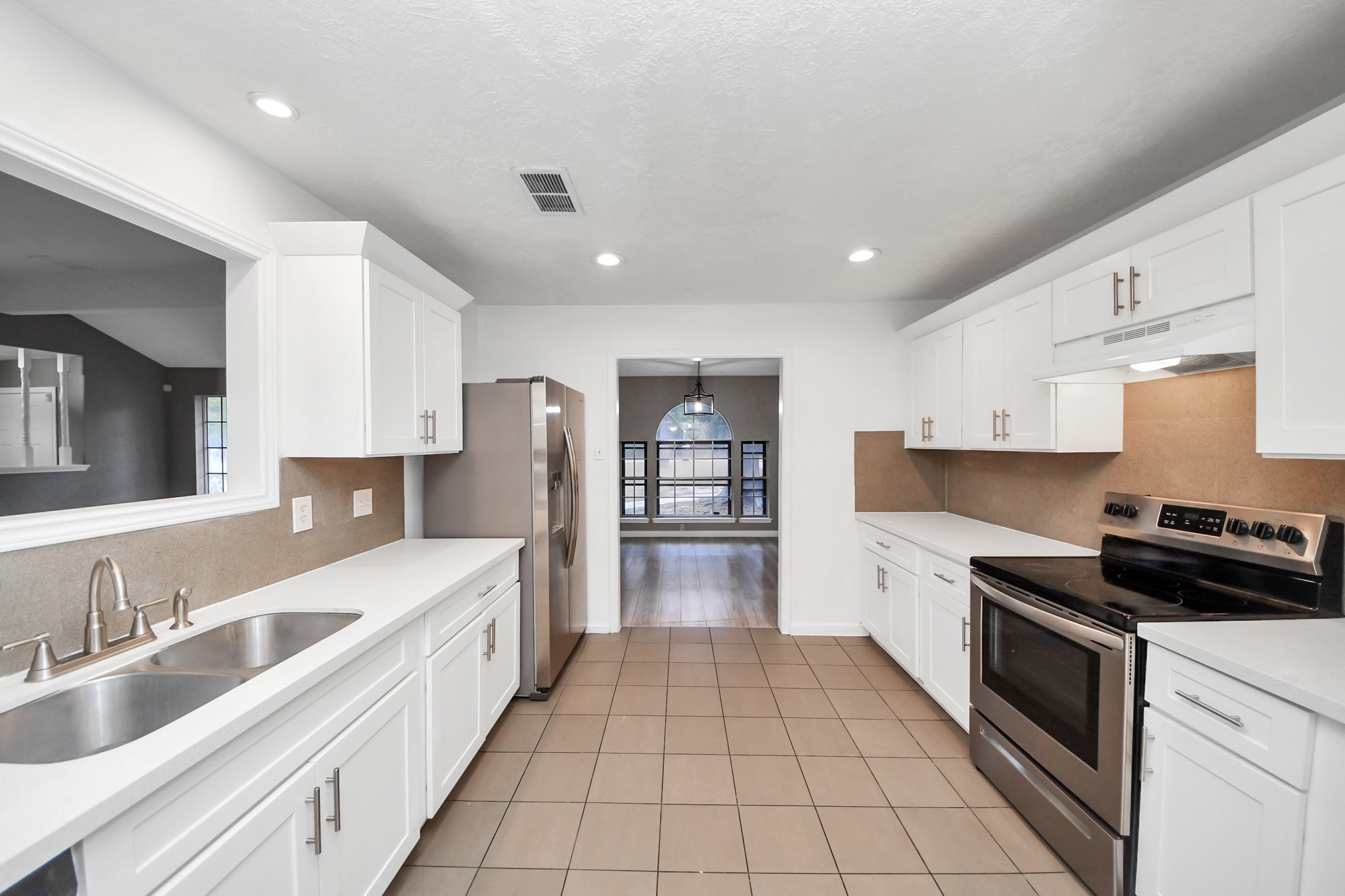 411 Dover Lane Spring, TX 77373 - Photo 18 of 40 a kitchen with a sink stove and refrigerator
