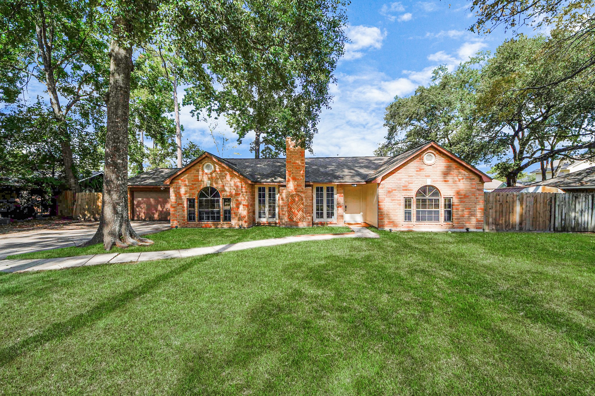 411 Dover Lane Spring, TX 77373 - Photo 5 of 40 a view of a white house with a big yard and large trees