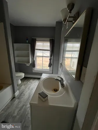 a bathroom with a sink a window and tub