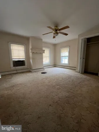 a view of empty room with window and fireplace
