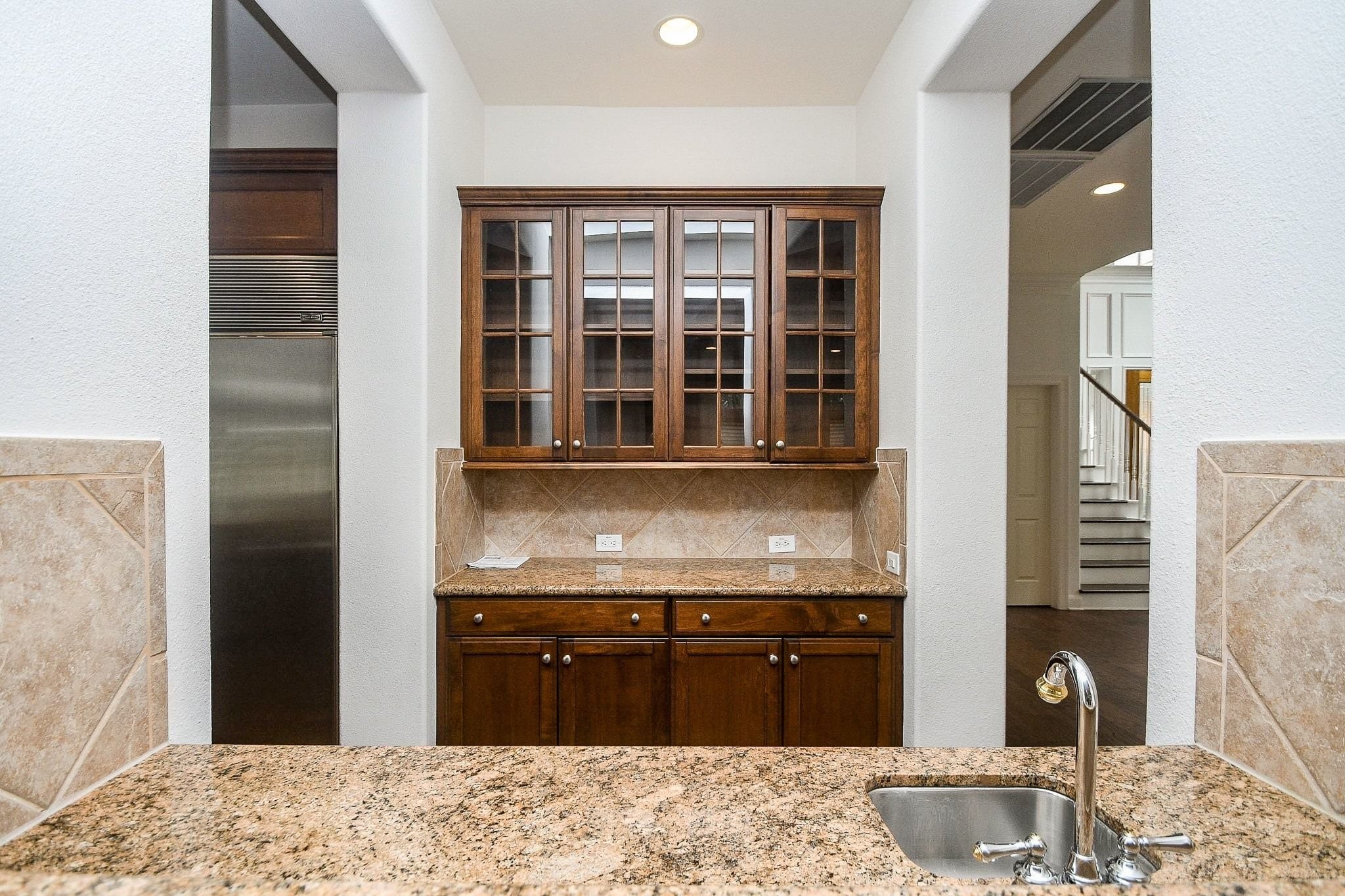 2826 Tudor Manor Houston, TX 77082 - Photo 10 of 37 Spacious butler's pantry featuring custom glass-front cabinetry, ample counter space, and a convenient sink.