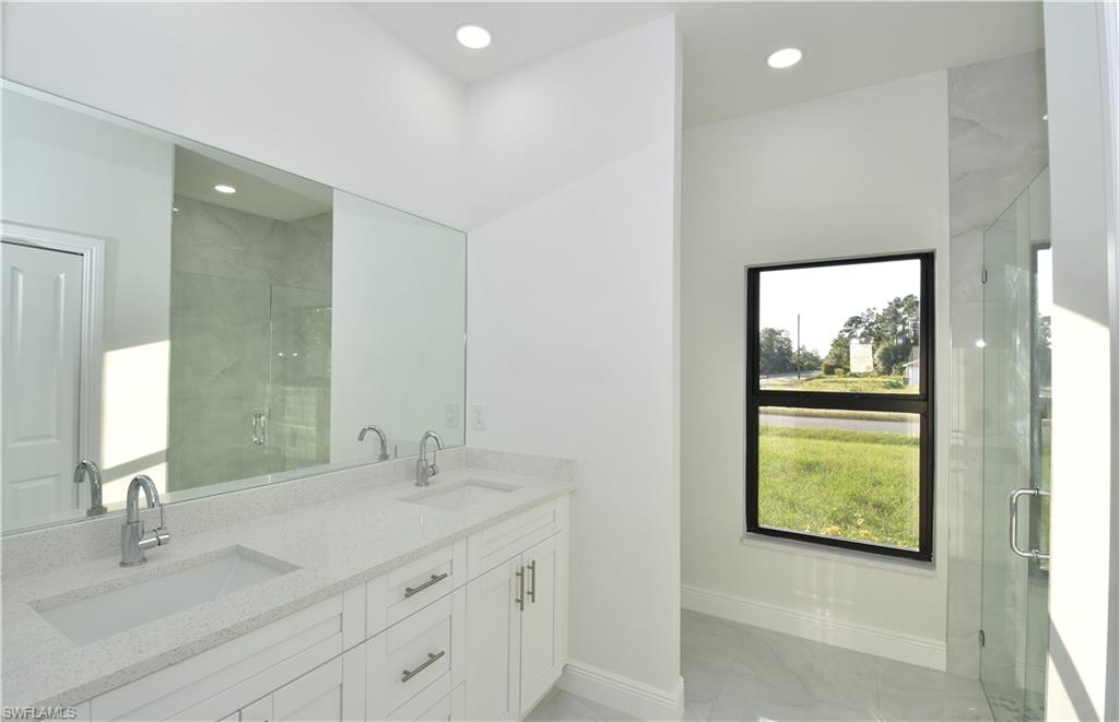 349 Naples Avenue South Lehigh Acres, FL 33974 - Photo 14 of 22 a bathroom with a granite countertop sink a toilet and a mirror