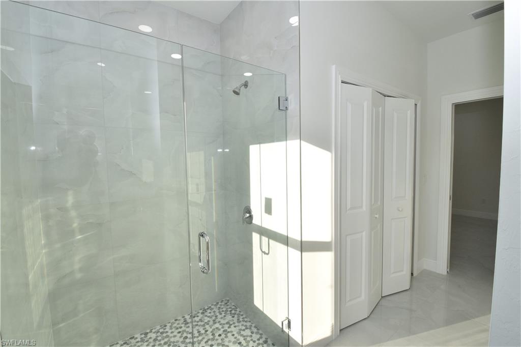 349 Naples Avenue South Lehigh Acres, FL 33974 - Photo 15 of 22 a bathroom with a glass shower door