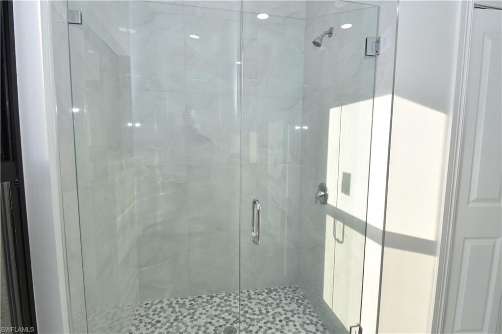 349 Naples Avenue South Lehigh Acres, FL 33974 - Photo 16 of 22 a bathroom with a glass shower door