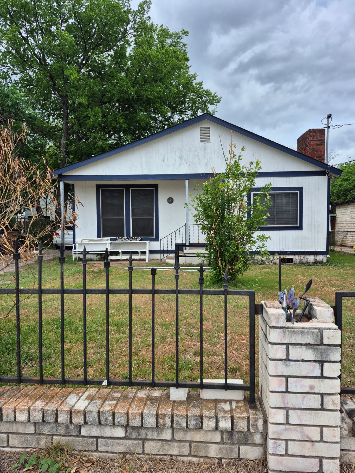 Bungalow-style house featuring a fenced front yard and a chimney