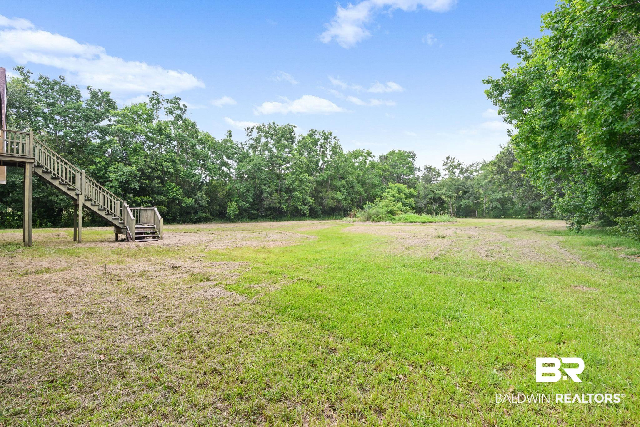 7540 2 Mile Road Irvington, AL 36544 - Photo 79 of 82 Expansive outdoor grounds featuring a large grassy area with varied green tones, bordered by mature trees