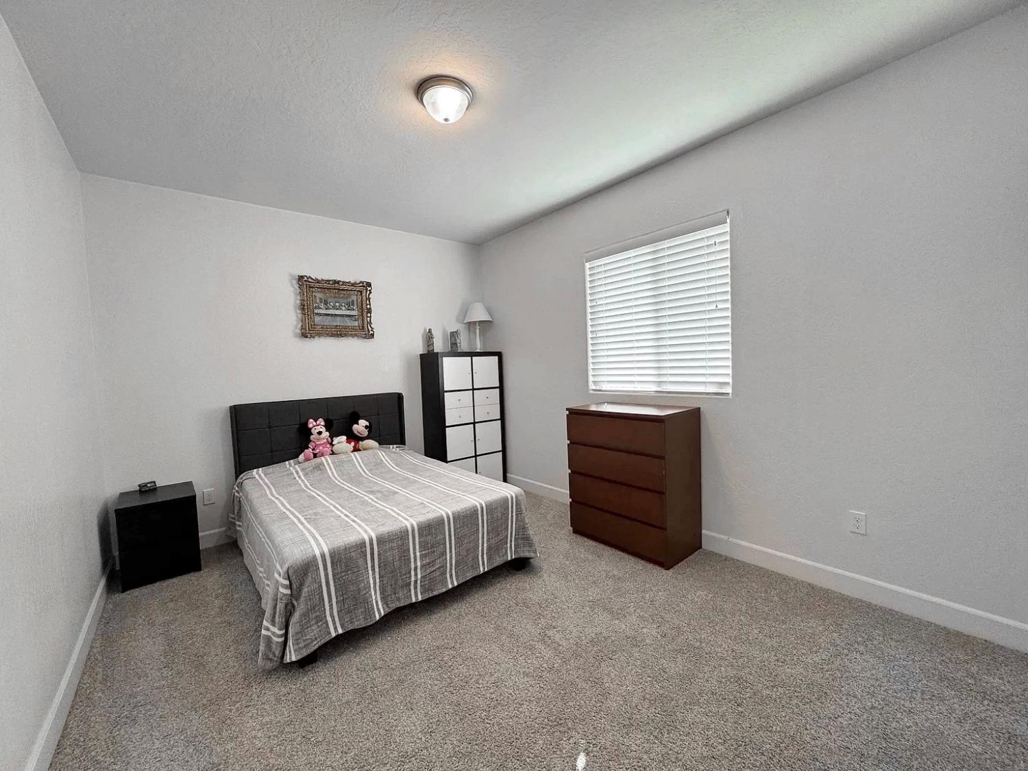 1405 West Tyler Court Visalia, CA 93291 - Photo 13 of 28 a bedroom with a bed and a window