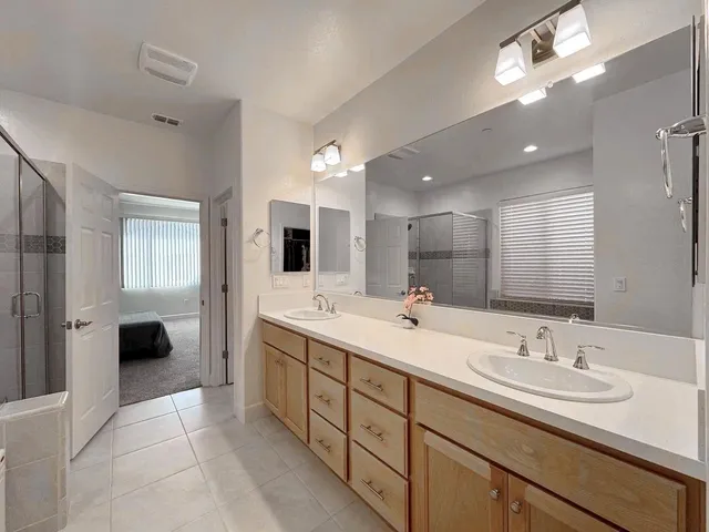 a spacious bathroom with a double vanity sink shower and a mirror
