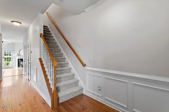 a view of staircase with wooden floor and white walls