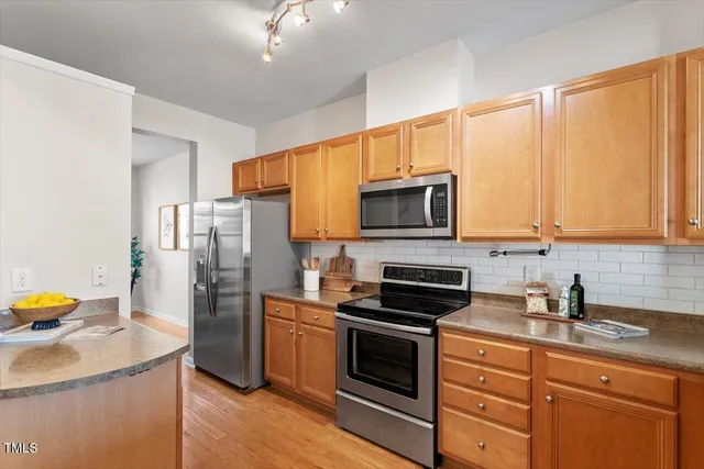a kitchen with stainless steel appliances a stove microwave and refrigerator