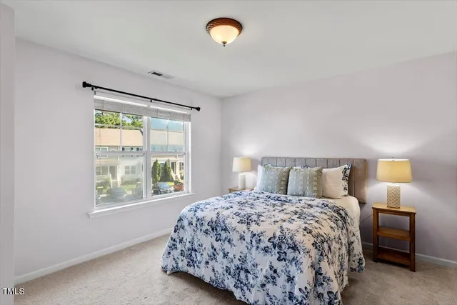 a bedroom with a bed and a lamp next to a window