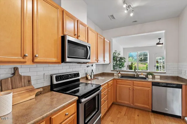 a kitchen with stainless steel appliances a sink stove and microwave