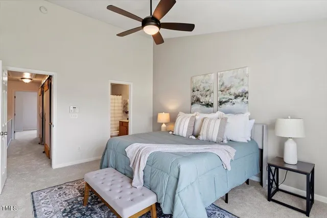 a bedroom with a bed and a lamp on a dresser