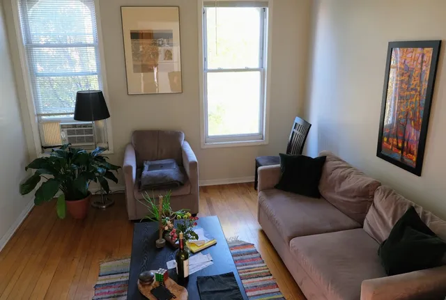a living room with furniture a window and a flat screen tv