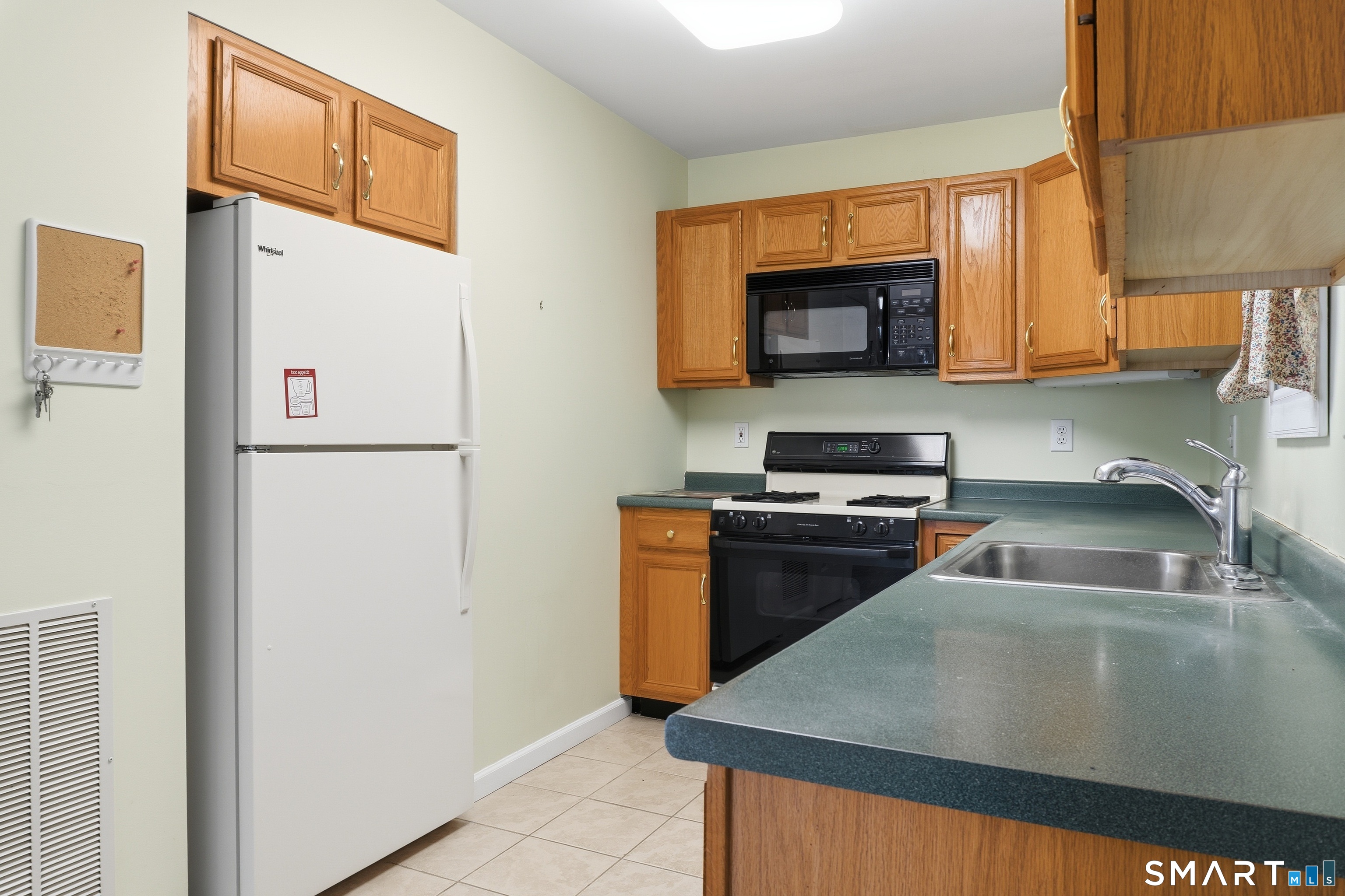 202 Stoney Way, Unit 202 New Fairfield, CT 06812 - Photo 6 of 18 a kitchen with a refrigerator and a sink
