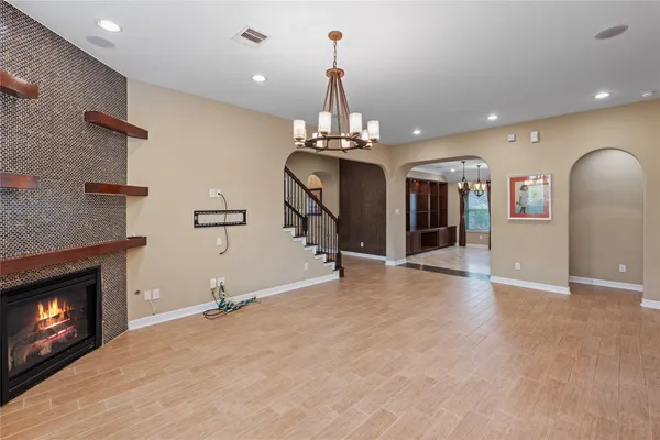 a view of a room with a fireplace chandelier and windows