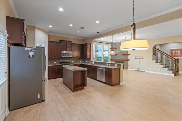 a kitchen with stainless steel appliances granite countertop a stove a sink a refrigerator and a microwave