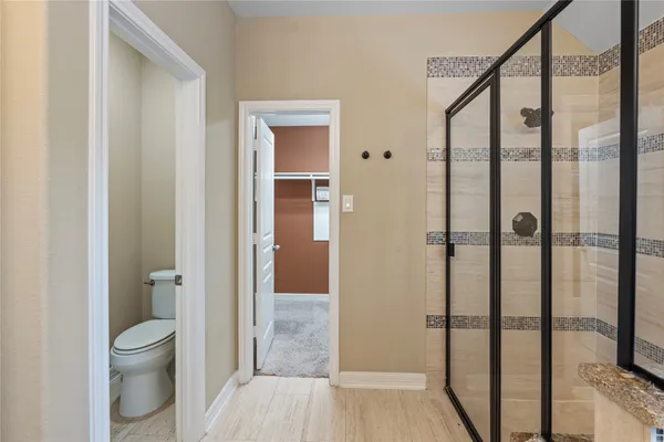 a bathroom with a toilet and a shower