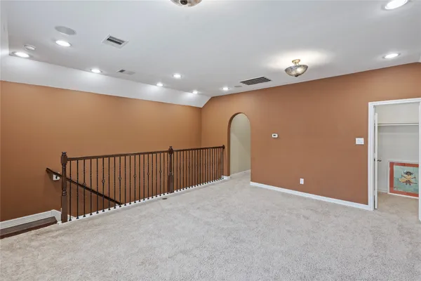 a view of an empty room with furniture and window