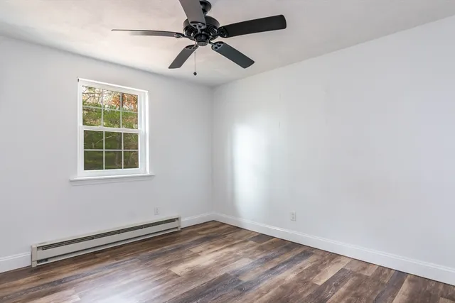 an empty room with a window and a fan
