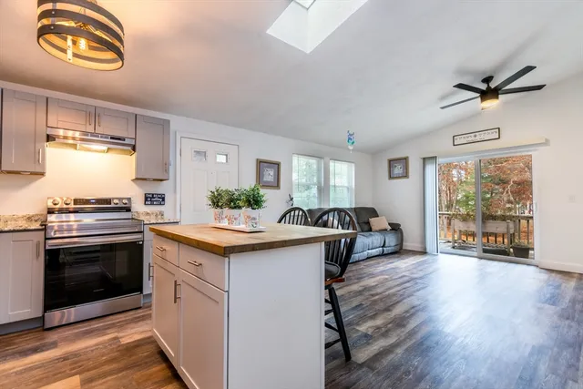 a kitchen with granite countertop a stove and a wooden floors