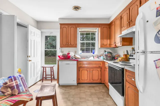 a kitchen with granite countertop a stove top oven sink and a window