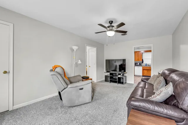 a living room with furniture a fireplace and a chandelier