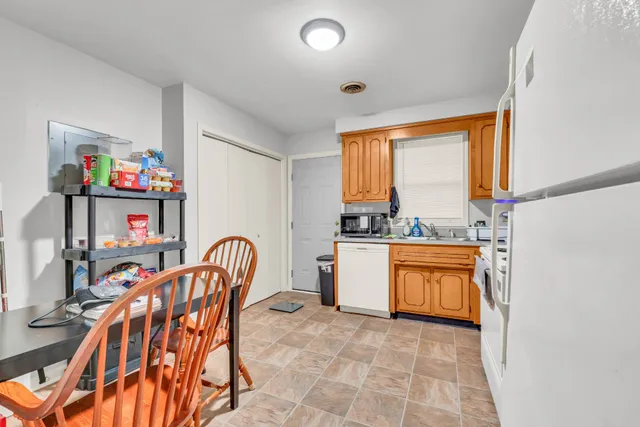 a kitchen with stainless steel appliances granite countertop a dining table chairs sink and cabinets