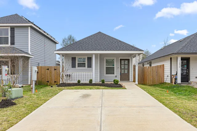 a front view of a house with a yard and trees